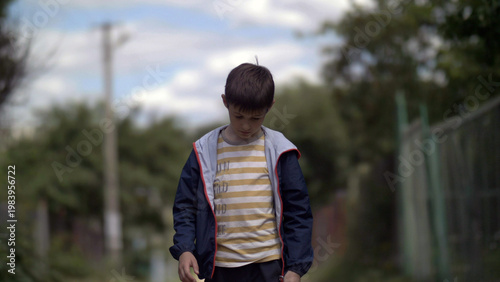 Schilderij op canvas lonely sad boy walking along the village road with head down, ruffian naughty bo