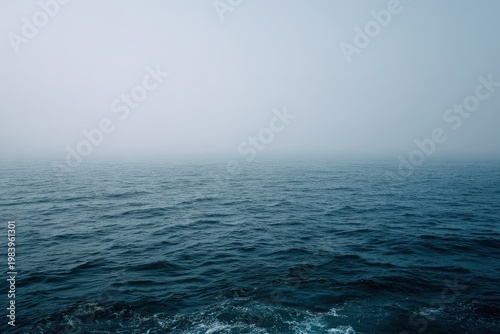 Misty ocean morning with rippling blue water and faint horizon, a serene