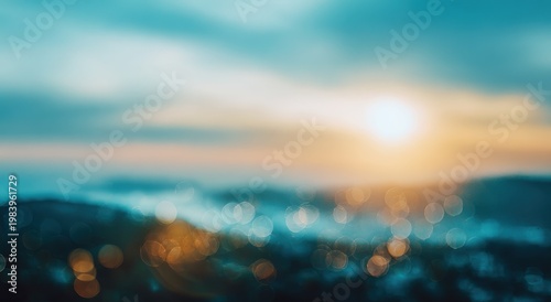 Blurred landscape with soft blue sky, sunset glow, and bokeh lights