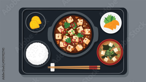 Complete Japanese bento tray featuring mapo tofu in a clay pot served with white rice miso soup and pickles.