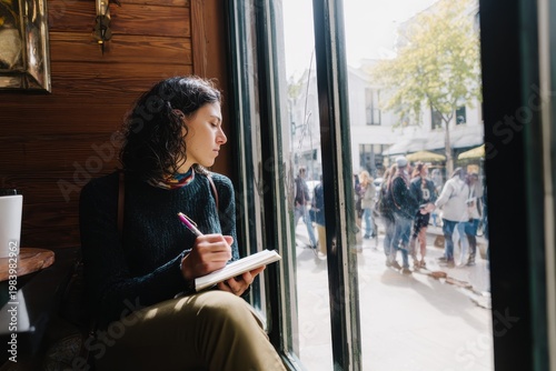 Solo traveler writing in a journal at a busy cafe, looking out the window, introverted but content