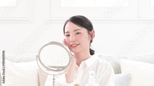 鏡で肌を確認する日本人女性