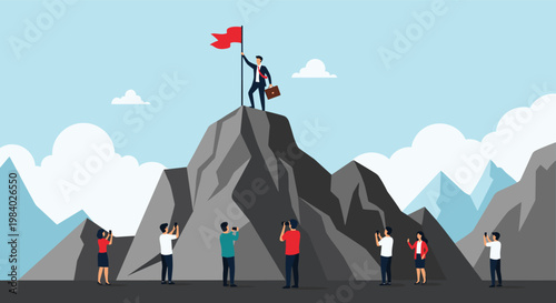 Businessman holding a flag at the summit of a mountain while a crowd of people below takes photos of his success.