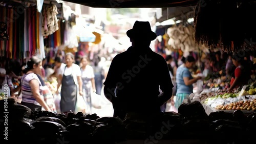 Silhouette of a person at a market stall with merchandise and shoppers