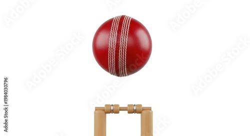 Red cricket ball suspended above stumps in mid-air for a potential wicket