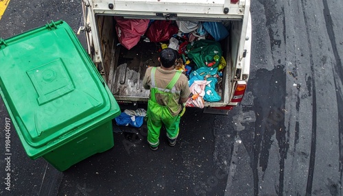 녹색 작업복을 입은 환경미화원이 거리에 놓인 초록색 쓰레기통 옆에서 트럭에 폐기물을 수거하며 도시 환경을 깨끗하게 유지하는 모습