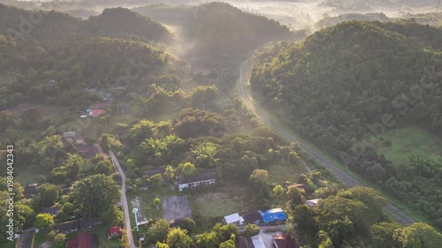 Aerial photograph of mountainous landscapes and villages in northern Thailand, shrouded in mist and morning light in Lampang Province, Thailand.