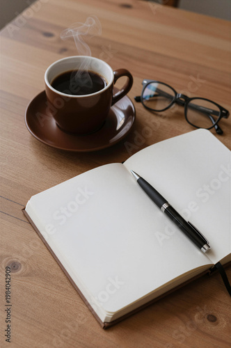 Blank Notebook with Steaming Coffee and Eyeglasses on Wooden Table