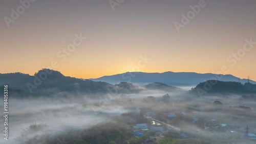 Aerial photograph of mountainous landscapes and villages in northern Thailand, shrouded in mist and morning light in Lampang Province, Thailand.