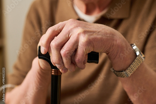 Foto Close up of senior Caucasian man gripping walking cane, showing mobility support and aging care needs