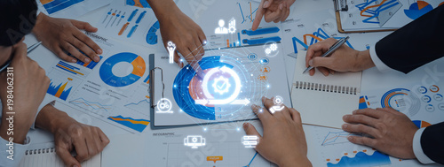 Tableau sur toile A dynamic business meeting scene showcasing hands working on data analysis, graphic charts, and digital icons, representing collaboration and innovative ideas