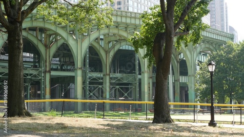 New York City, Manhattan, United States of America. Riverside Park South. Miller highway remnant, elevated viaduct in Upper West Side. Green arch of overpass bridge ruins near baseball sport field.