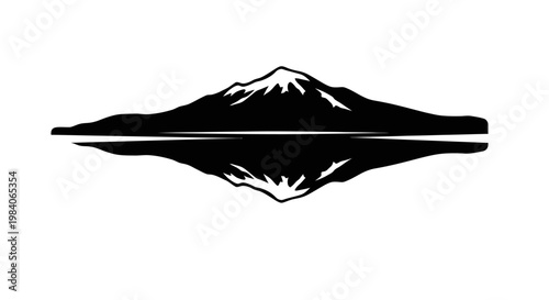 Silhouette of a snowy mount.ain reflected in a calm lake.