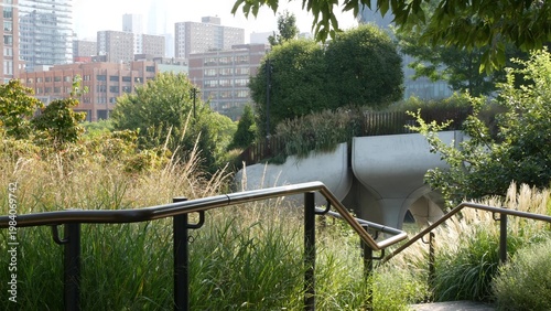 New York City Little Island pier park in Midtown of Manhattan, United States. Urban garden oasis on pillars in Chelsea, USA. Biophilic design, eco flora, plants and greenery. Residential buildings.