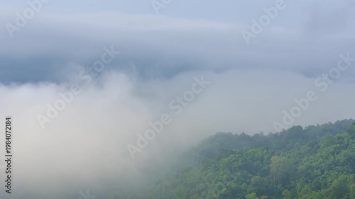 4K video of an aerial view of beautiful clouds or fog moving over the mountain peaks in northern Thailand.