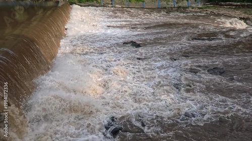 Aerial 4K view of a powerful river flowing with muddy brown water after heavy