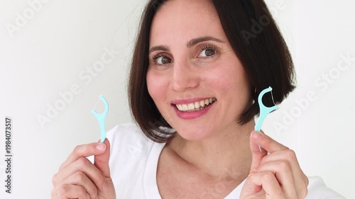 Young Woman Using Blue Plastic Dental Floss Pick on White Healthy Teeth — Female Interdental Cleaning with Disposable Flosser, Oral Hygiene Daily Routine, Gum Care and Preventive Dentistry