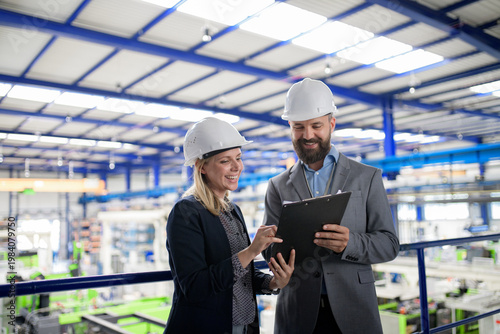 Foto Industrial team analyzing data in high tech manufacturing plant.