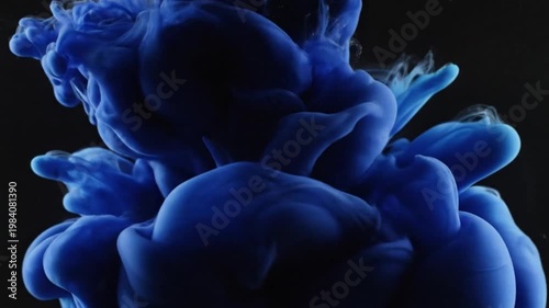 Abstract vibrant blue ink cloud blooming and swirling in dark water creating dynamic fluid art forms
