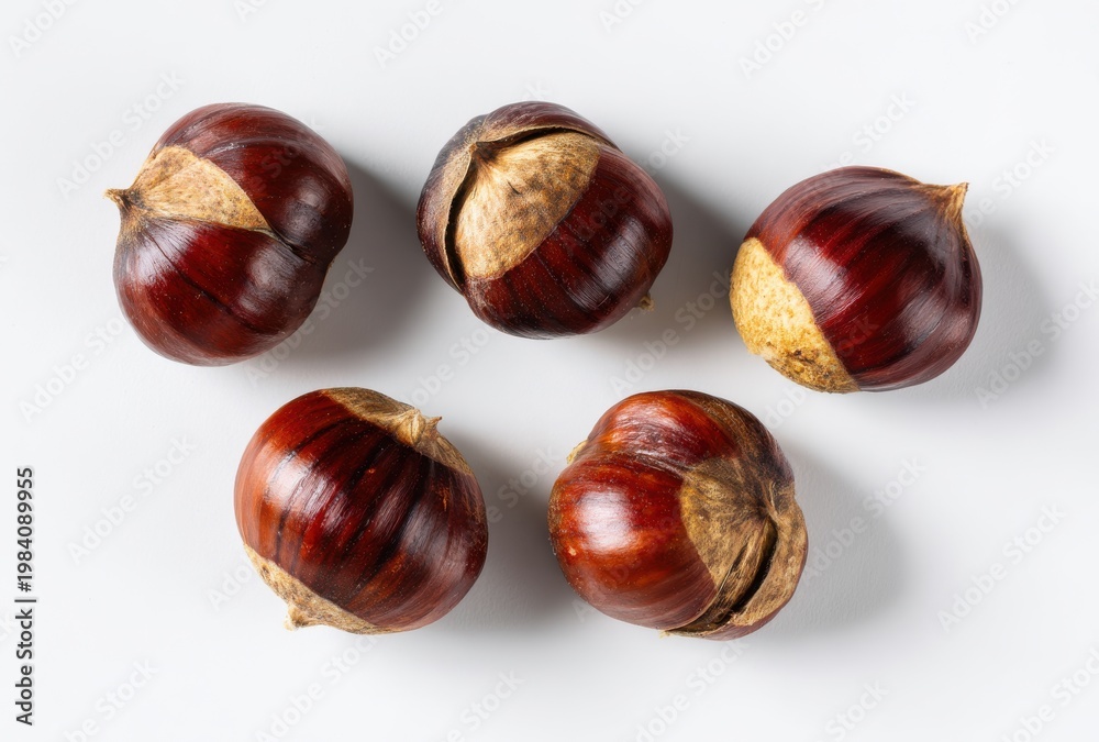 Obraz premium Five Fresh Shiny Brown Chestnuts Arranged Artfully on a Clean White Background Surface Top View