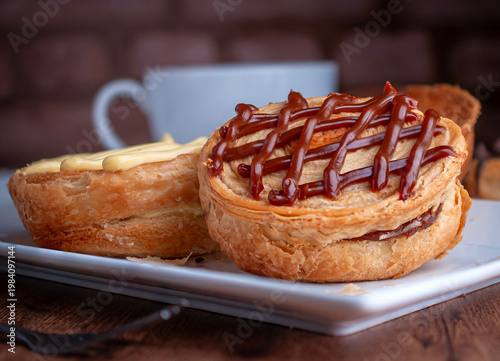 Reposteria casera, pan de hojaldre sobre un plato blanco para disfrutar en familia con cafe o leche, cubierta de cajeta
