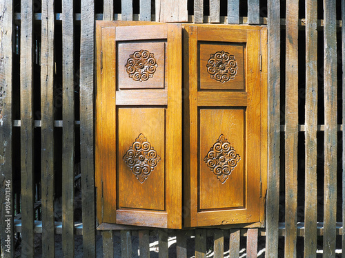 The windows with beautiful architraves in old wooden house.
