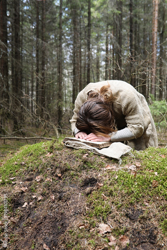 Fotografie A man in a cassock spends a ritual in a dark forest