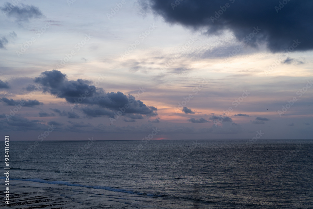 Fototapeta premium Overcast sky with dramatic clouds over calm ocean at Balangan Beach