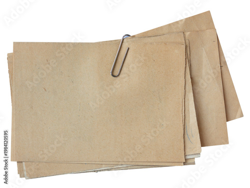 Stack of vintage brown paper sheets fastened with metal paper clip isolated on white