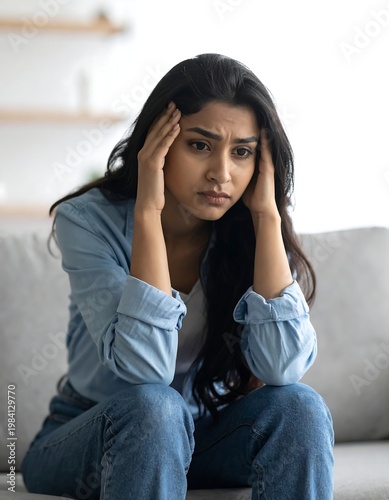 Woman with hands on head, showing stress and worry, at home