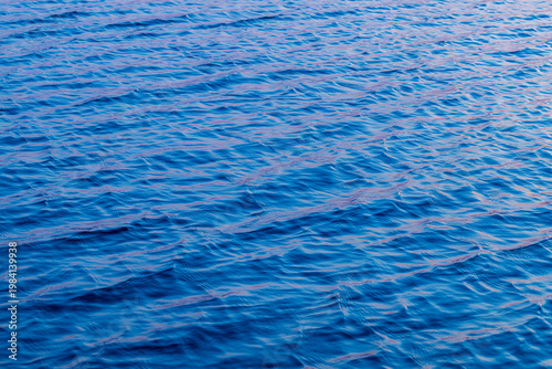 Canvastavla Blue Water Surface with Gentle Ripples and Sunset Reflections,A high-angle, full