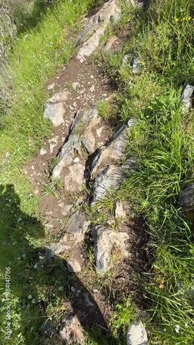 Hiker man tourist is going on a mountains pathway on the background of a mountain river