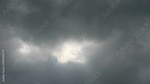 Huge heap dark gray cloud slow moving pass the sun