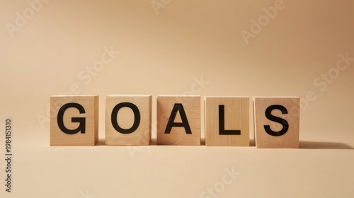 Wooden cubes spell out GOALS in bold black letters on a neutral background, symbolizing focus and achievement with a min