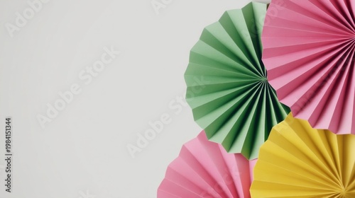 Modern minimalist still life with colorful paper fan decorations arranged diagonally, featuring vibrant pink, green, and