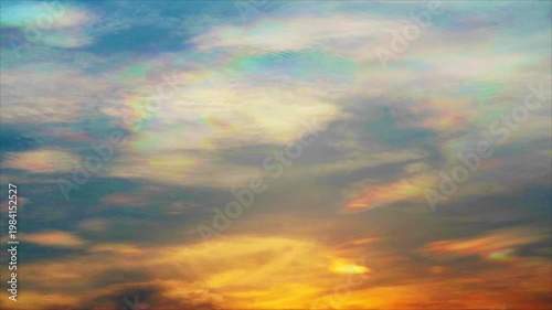 Iridescent cloud or rainbow cloud on the yellow orange sunset sky on the summer