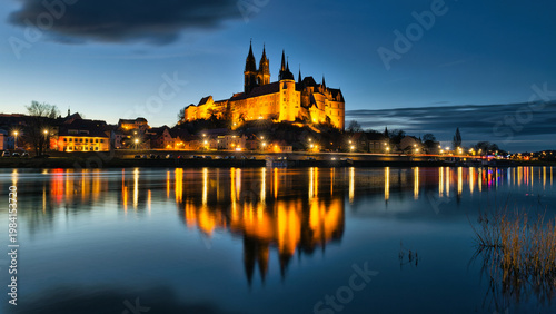 Illuminated Albrechtsburg Castle and Meissen Cathedral reflecting in Elbe river at night, Saxony, Germany
