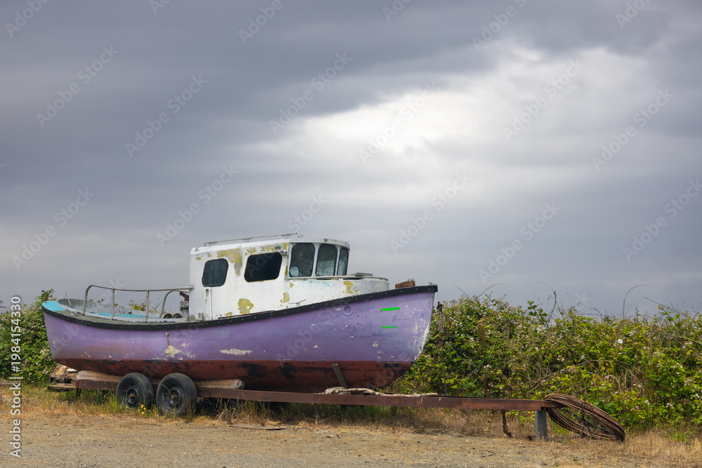 Fototapeta premium Purple abandoned fishing boat on a trailer