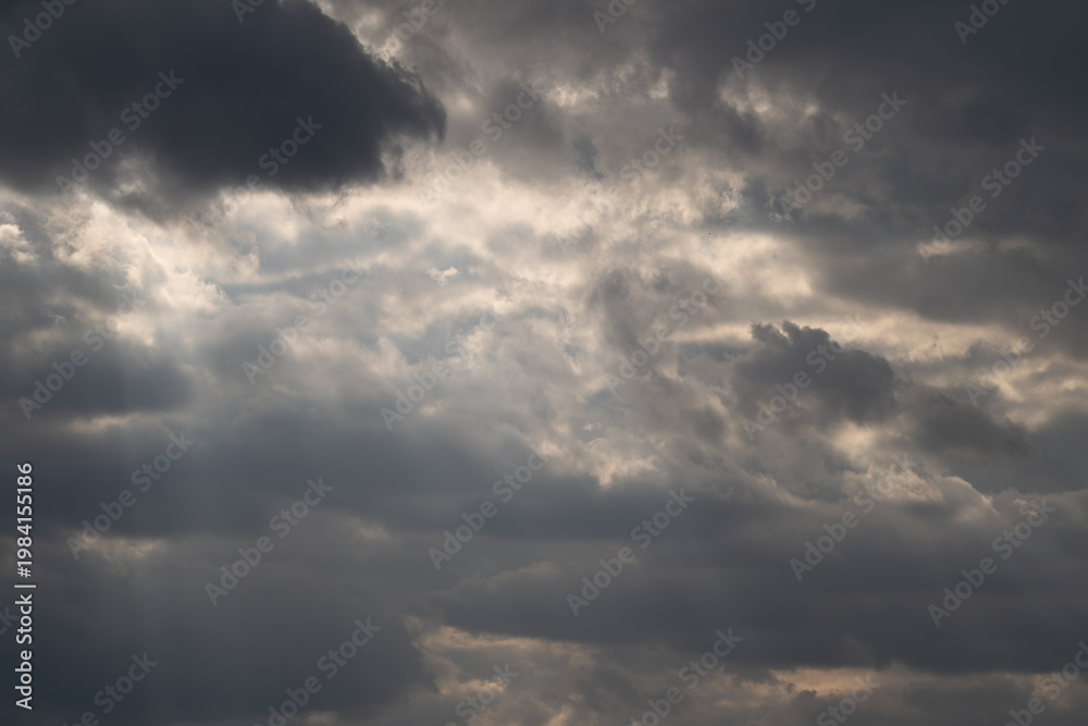 Obraz premium Cinematic clouds with light beams piercing sky, sweeping rays creating crepuscular effect, soft highlights on cloud edges, inspirational mood for film and landscape projects