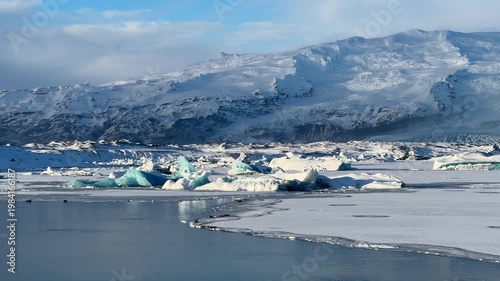 Luminous icebergs drifting on Jökullsarlon glacier lake in southern Iceland