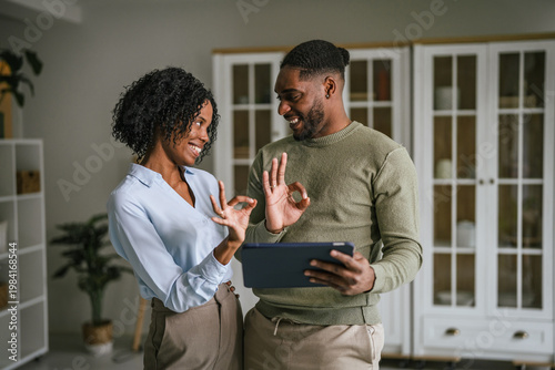 Happy couple communicating using sign language and tablet