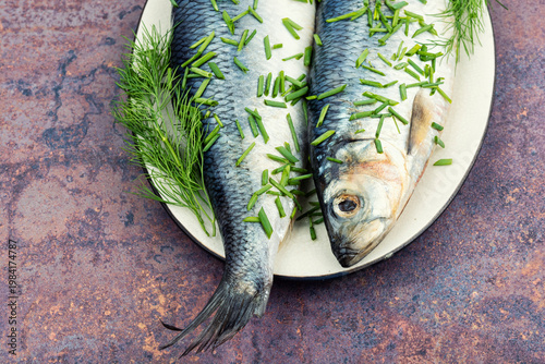 Whole Salted Herring Fish with Dill on Ceramic Plate