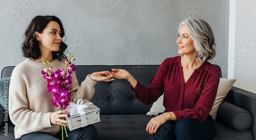 Woman giving gift to senior mother.