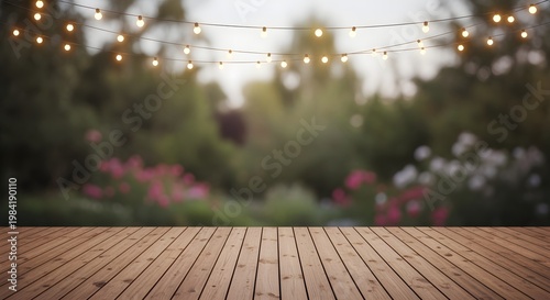 Wooden deck with string lights and blurred background of lush greenery, perfect for outdoor events.