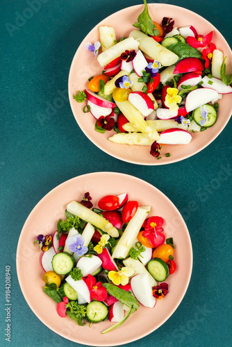 Colorful Vegetable Salad with Asparagus, Radishes and Edible Flowers on a Plate