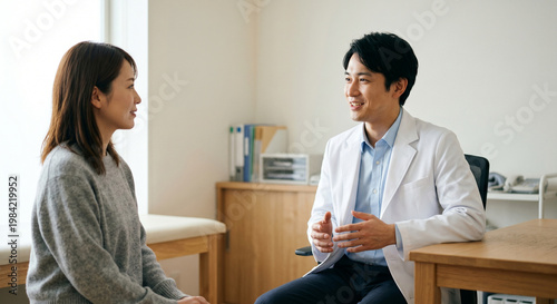 診察室で笑顔で会話をする男性医師と女性患者