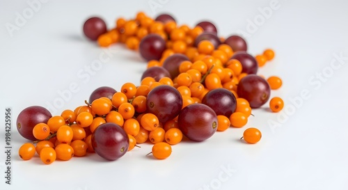 Vibrant Arrangement of Sea Buckthorn Berries and Plums on White Surface.