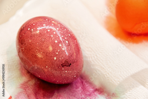 Vibrant pink speckled Easter egg, freshly dyed, on a paper towel