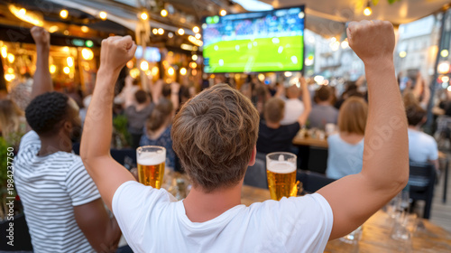 Football fans celebrating world cup match on outdoor terrace with drinks