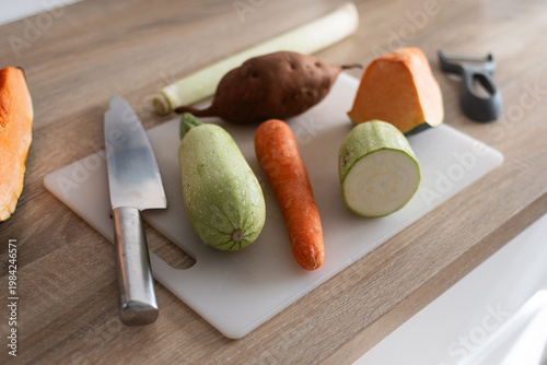 Fotografie Fresh vegetables on cutting board with zucchini carrot potato and pumpkin on kit
